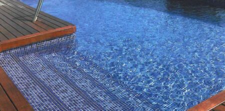 Piscina rectangular con escalera interior lateral con coronación de madera