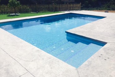 Piscina rectangular 8×4 con escalera lateral.