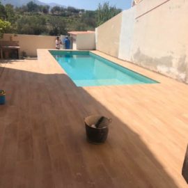 Piscina con terraza de gres porcelánico imitación madera